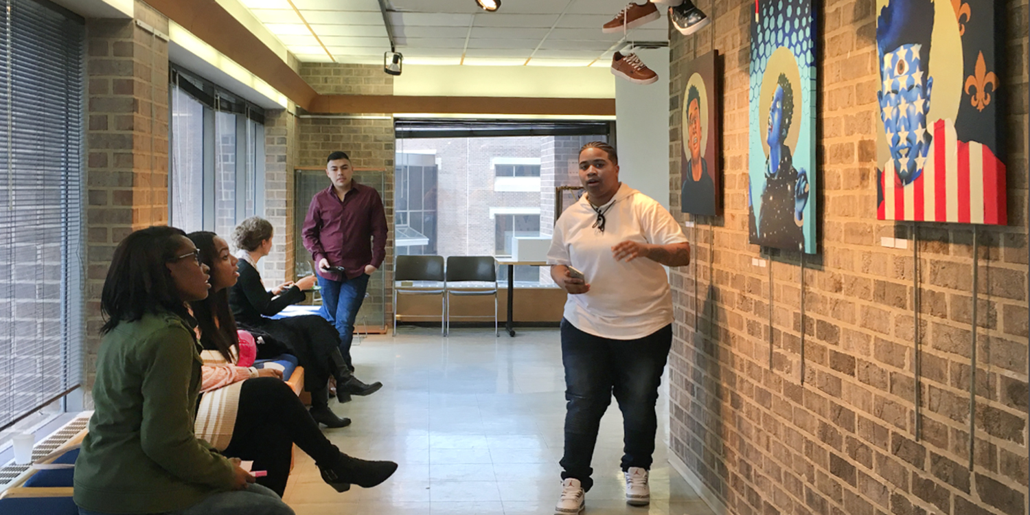 Senior Exhibition Student presenting work in portfolio exhibition