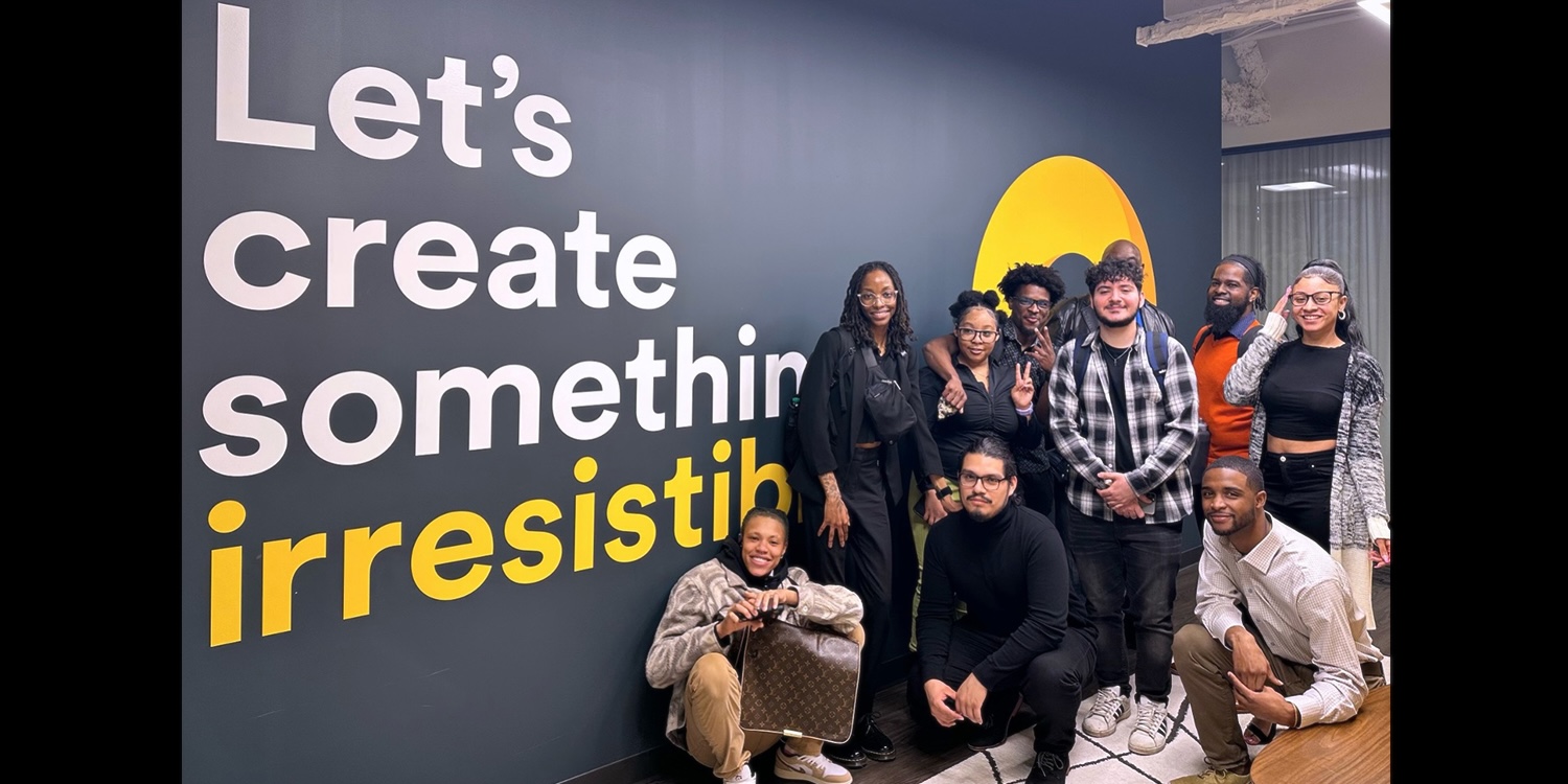 Group of students gathered around sign saying Let's Make Something Irresitible