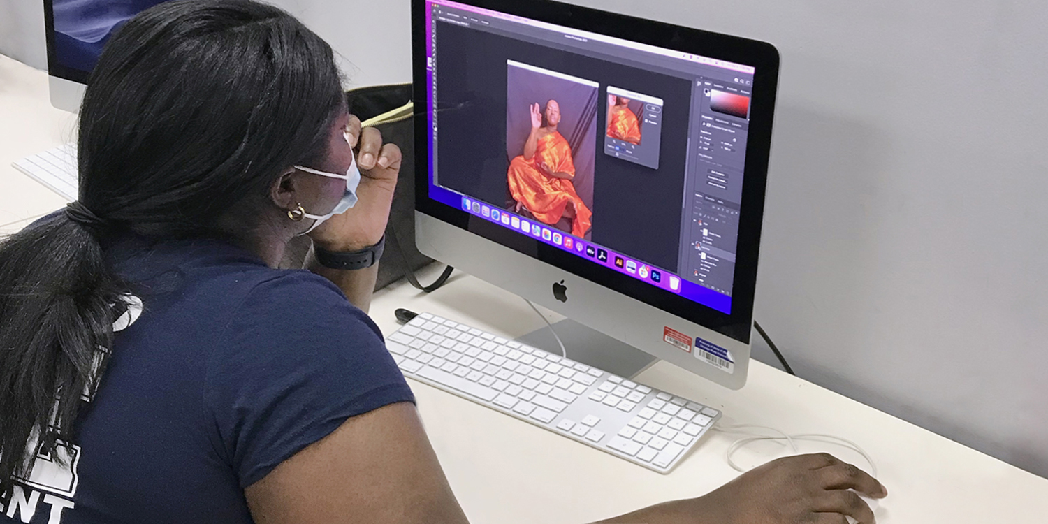 Student creating design and photo on computer