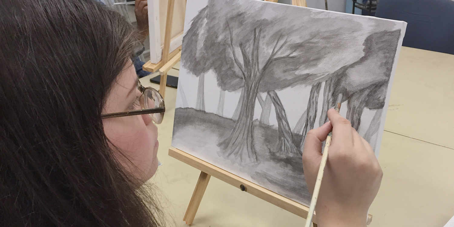 Student drawing landscape with trees