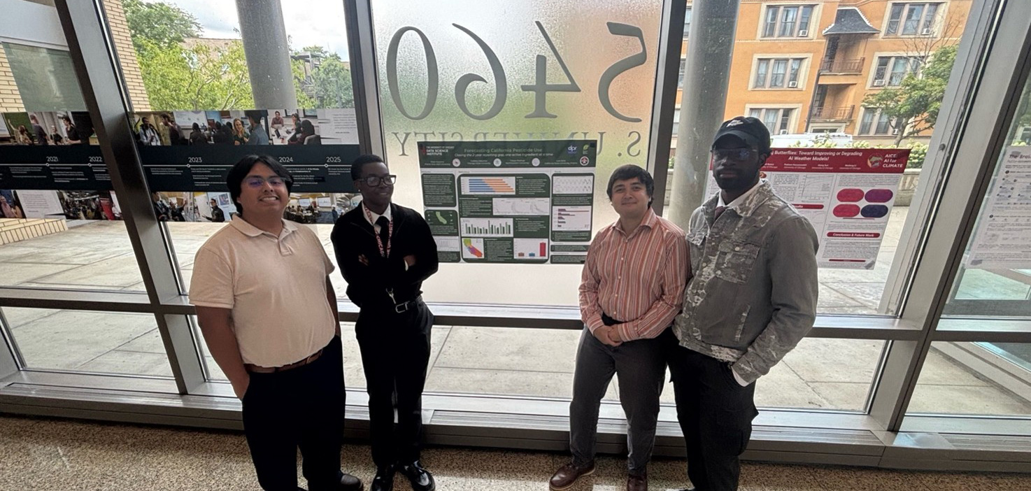 Four young men pose side-by-side in front of floor-to-ceiling windows. Research posters with data charts, maps, and timeline photos are mounted on the glass behind them.