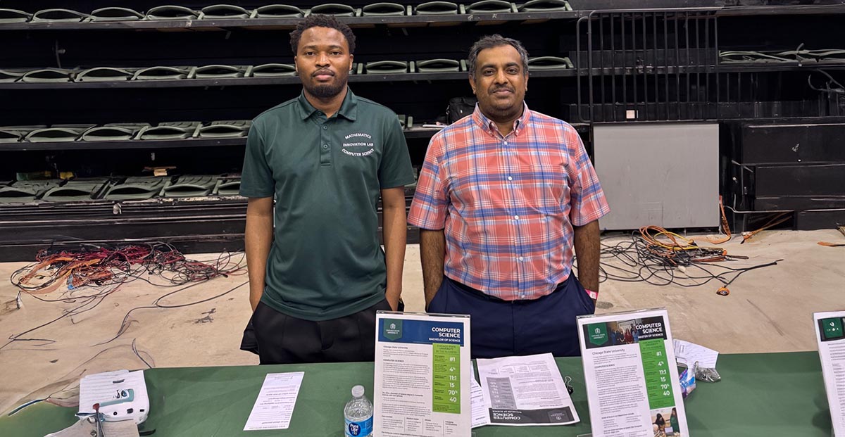 A CIMST student and Dr. Saif stand next to each other and smile behind a table for the computer science at the Black College Expo Event.