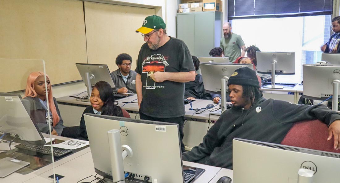 Faculty members and CIMST students assisting high school students in a computer lab.