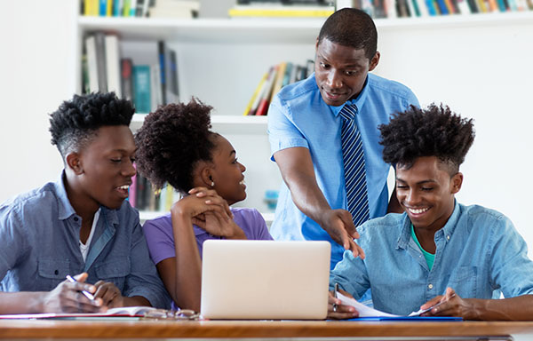 Teacher with students adn laptop