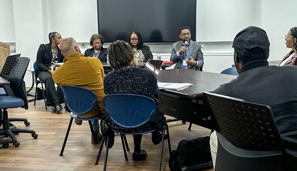 A panel of four speakers seated at a large table facing attendees during an industry day series event.