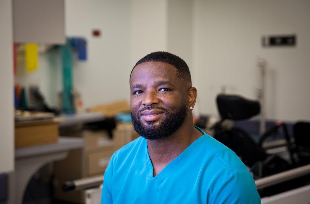 Up close portrait of Antoine Harris wearing cyan scrubs