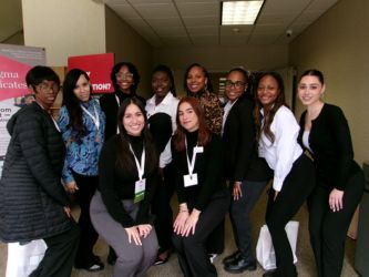 Ten members of the Chicago State Student Occupational Therapy Association wearing business professional clothing pose for a group photo at a conference