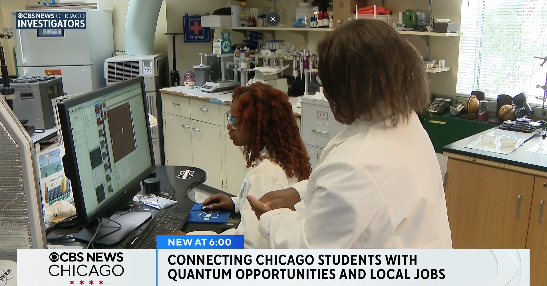 2 female students in lab coats doing research