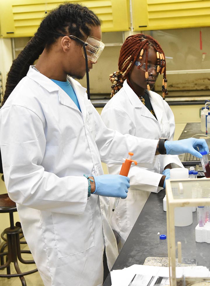 @ black students in white lab coats doing research.