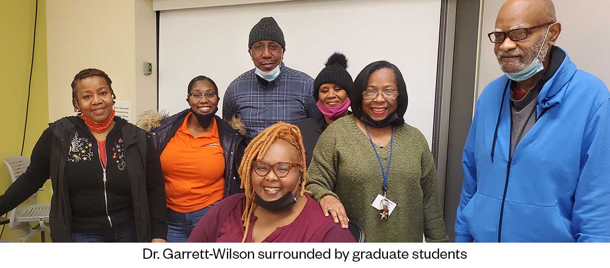 Dr. Garrett-Wilson surrounded by graduate students