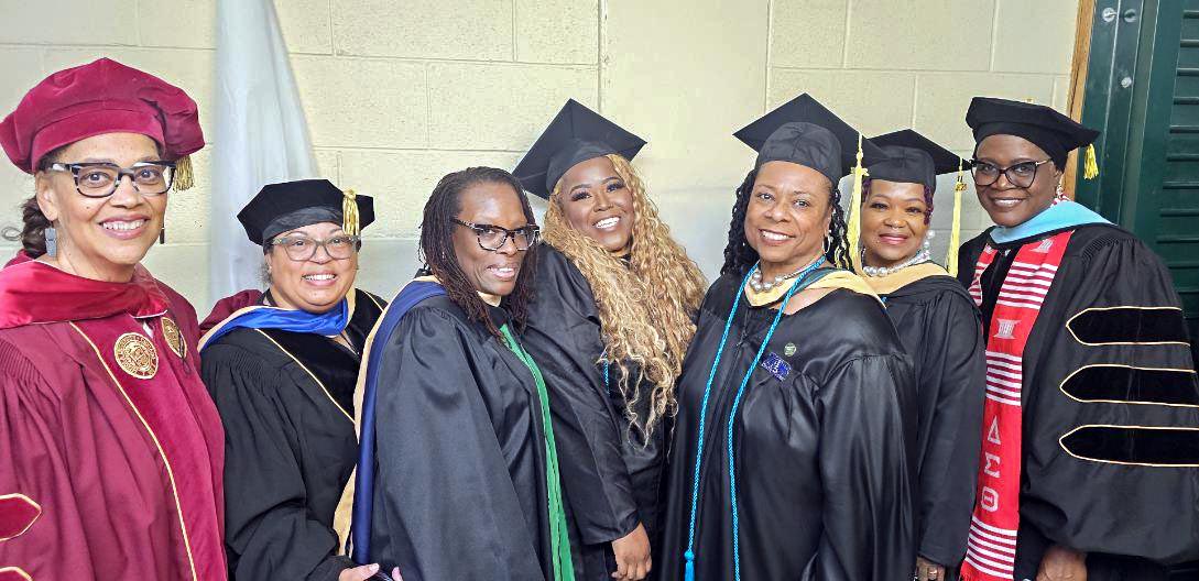 Social Work department chair Dr. Mann and director of the Dual Enrollment program Carolyn Wadlington smile with 2026 graduates of the social work program at Chicago State University.