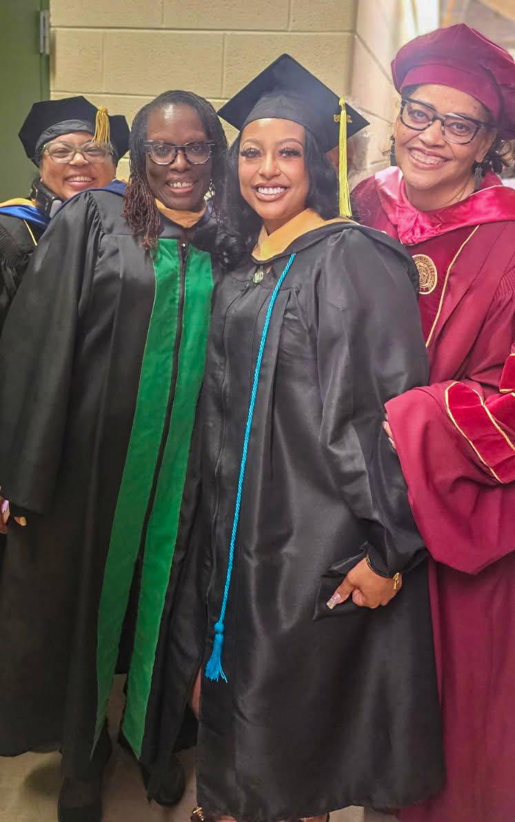Graduates pose for a photo with Dr. Mann.