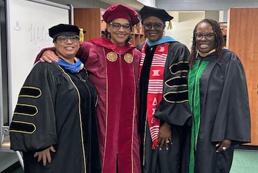 Dr. Mann, department chair for the social work program, smiles with graduates.